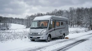 Camping-car stationné dans un paysage hivernal enneigé, prêt pour l'hivernage.